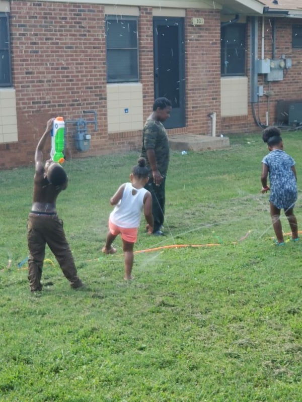 Four young children playing with water toys.