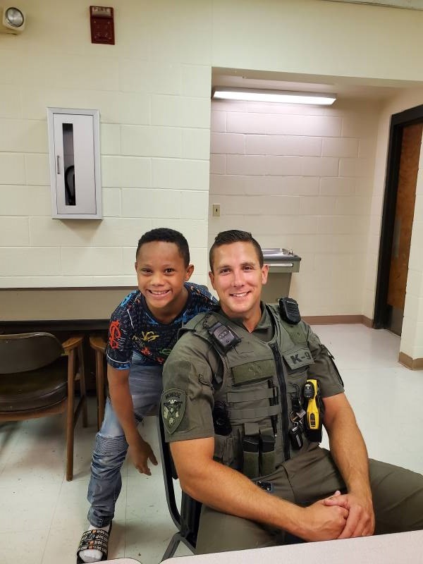 A young boy smiling with a police officer.