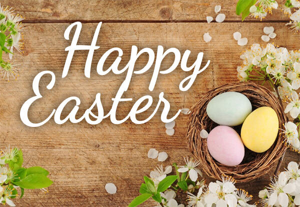 Happy Easter. Three colorful eggs sit in a nest on top of a wooden table.