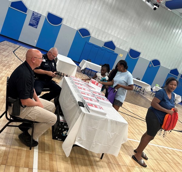 People getting information from two officers sitting at a table.