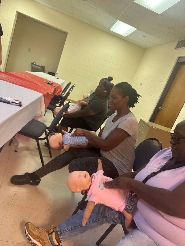 CPR students practicing with infant training dummies. 