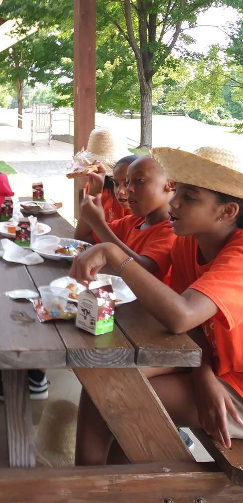 Kids in their hats at picnic table for meal