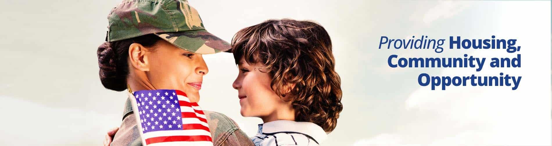 female military member holding child with an American flag in his hand